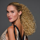 Woman wearing a 16in Coily Cinched Pony in Golden Wheat - Left side profile view