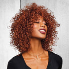 Woman wearing Sassy Curl Wig in Rooted Dark Copper 