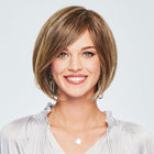 Woman wearing Simply Charming Bob Wig in Rooted Golden Wheat - View from the front
